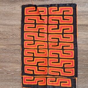 Red and Orange on Black Mola. Geometric Patterned Textile.